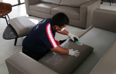 man on work cleaning big sofa