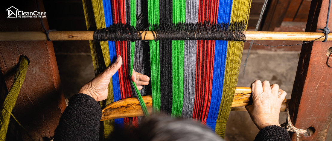 Close-up of hands weaving a colorful handwoven rug.